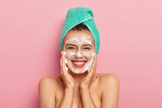 A woman smiles at the camera, her skin glowing and radiant after applying seamoss to her face.